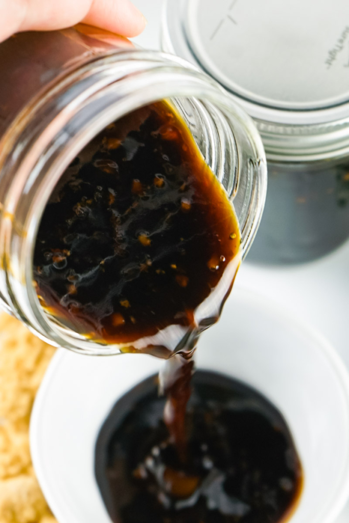 Pouring this teriyaki sauce from a glass jar. 