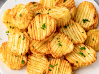 Crunchy golden air fryer accordion potatoes on a white plate.