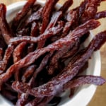 Air fryer beef jerky strips in a white bowl.