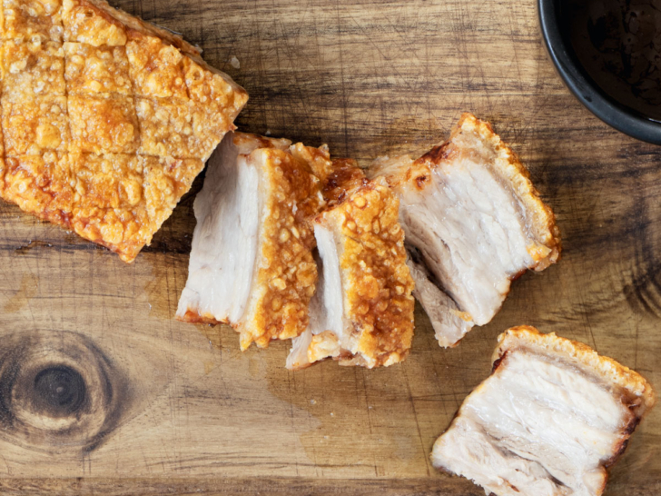 Crispy air fryer pork belly on a woode cutting board.