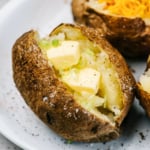 Air fryer baked potato on a white plate.