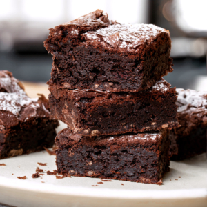 Air fryer brownies stacked on a white plate.