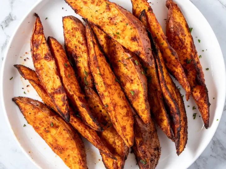 Air fryer sweet potato wedges on a white plate.