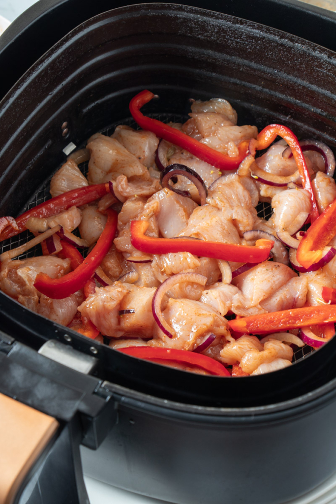 Chicken fajita filling in air fryer basket. 