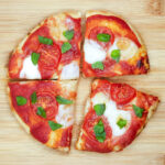 Air fryer flatbread pizza on a wooden board.