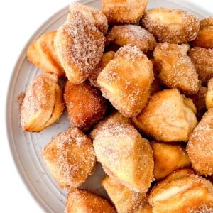 Air fryer cinnamon donut holes on a white plate.