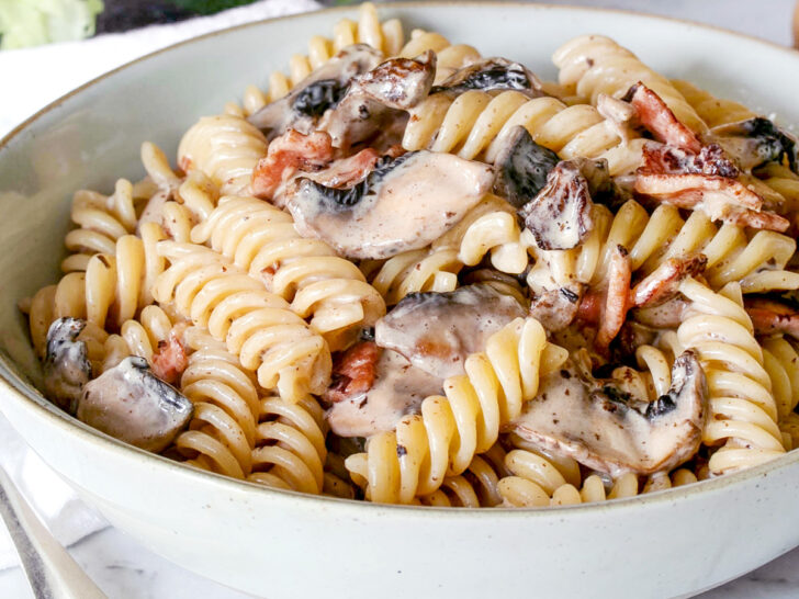 Creamy bacon mushroom pasta in a blue bowl.