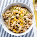 Creamy chicken and leek pasta in a white bowl.