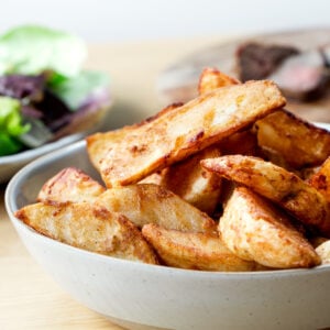 A bowl of air fried frozen potato wedges.