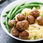Meatballs and mashed potato on a plate.