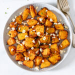 Air fryer pumpkin with feta on a white plate.