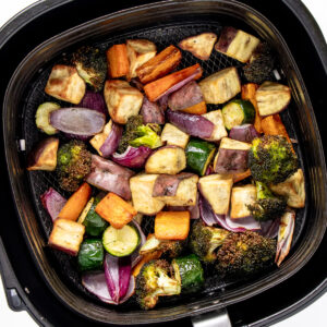 Air fried roased veggies in Rasted veggies in air fryer basket.