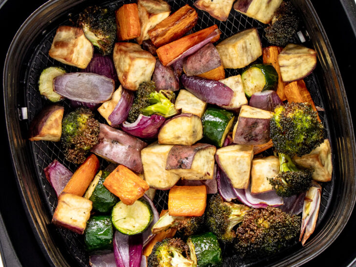 Air fried roased veggies in Rasted veggies in air fryer basket.