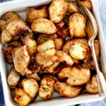 Air fryer smashed potatoes in a white serving dish.