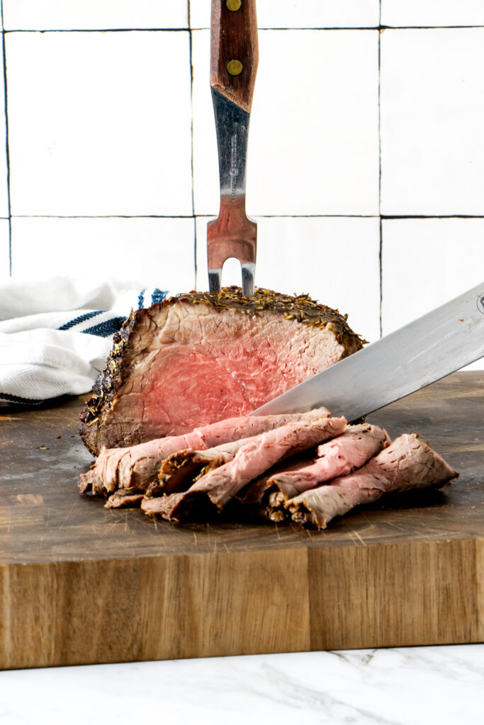 Air fried beef roast on a wooden board.