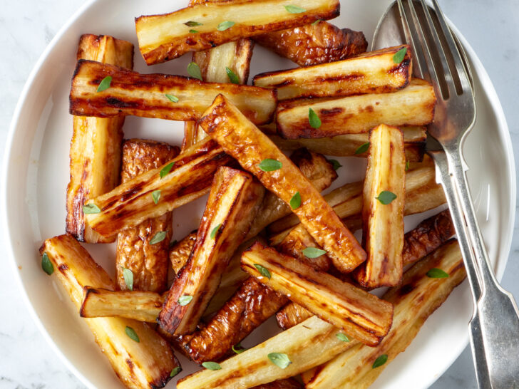 Air fryer pasnips on a white serving dish.