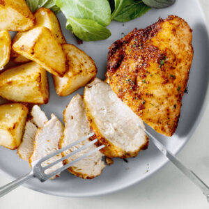 Air fryer chicken breast with potatoes and salad.