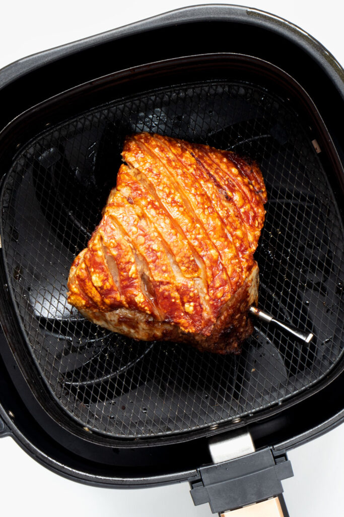 Roast pork in air fryer basket. 