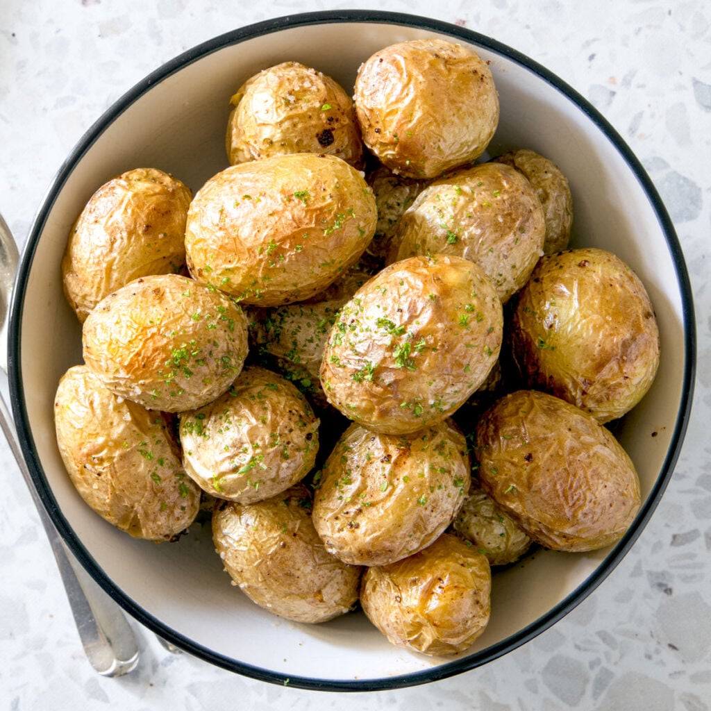 Air fryer baby potatoes in a white bowl.