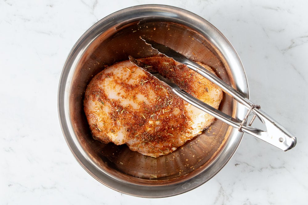 Seasoning chicken breast.
