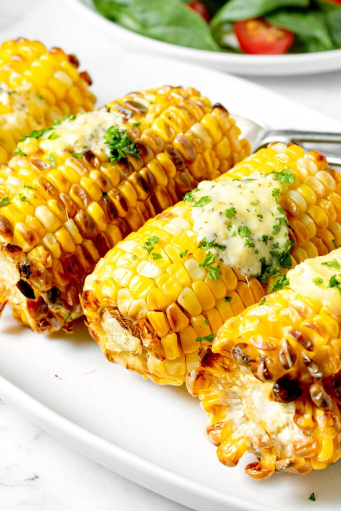 Air fried corn on the cob on a white plate.