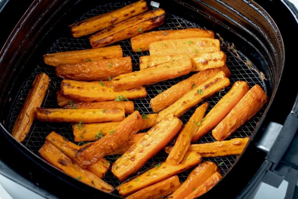 Air fried roasted carrots in air fryer basket. 