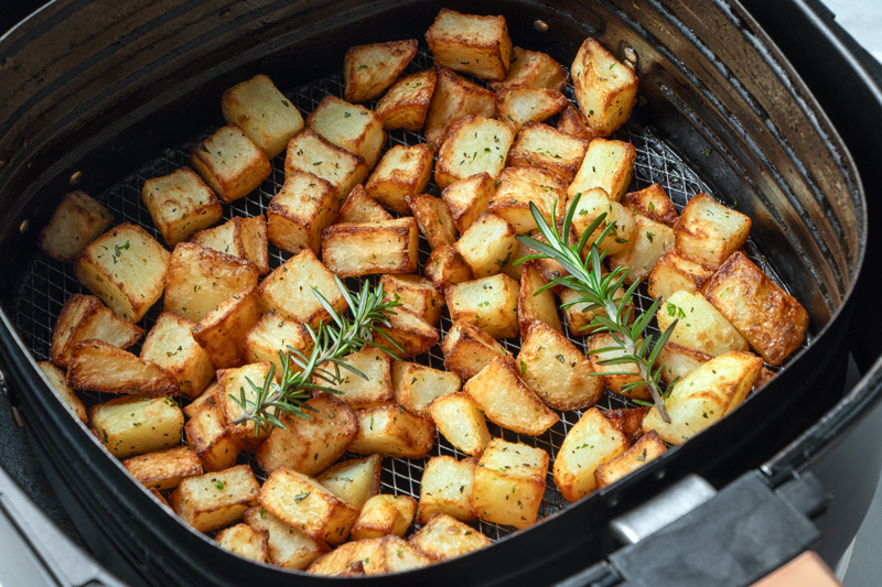 Cooked Parmentier potatoes in air fryer basket.