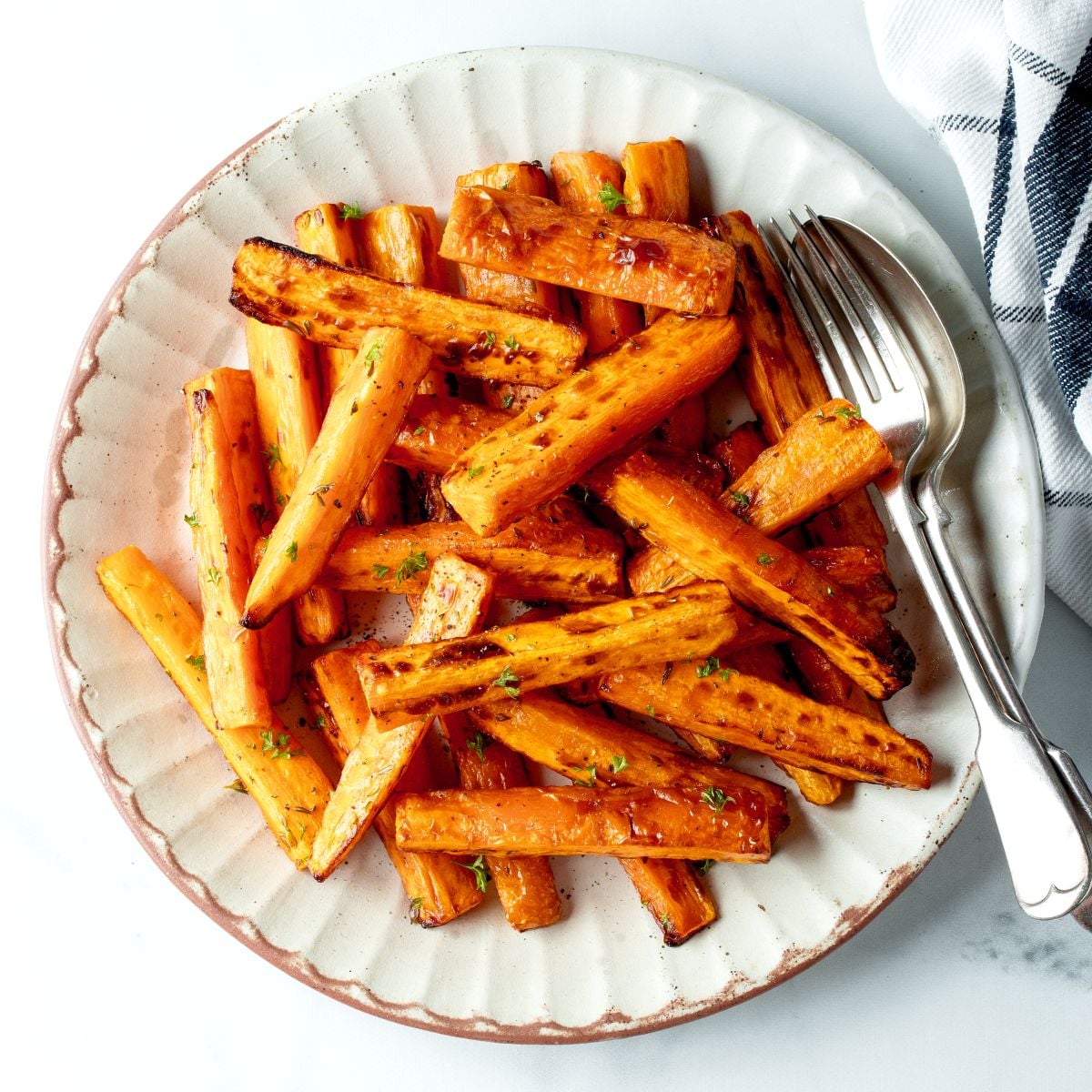 Air fryer carrots on a white plate.