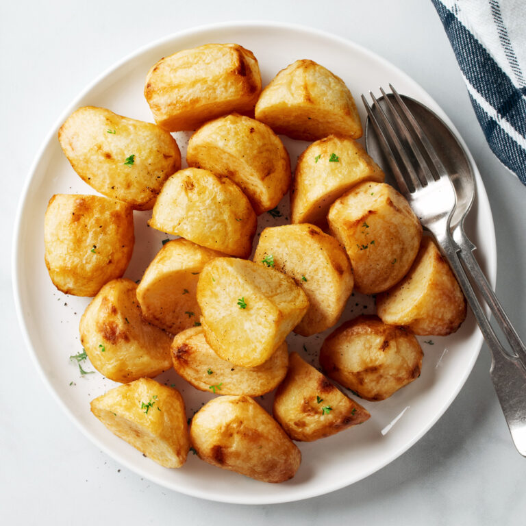 Air fryer roast potatoes on a white plate.